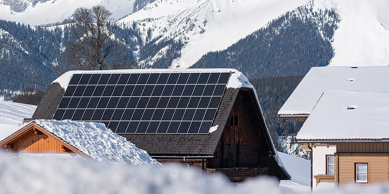 Eine Solaranlage auf einem Dach in winterlicher Landschaft 