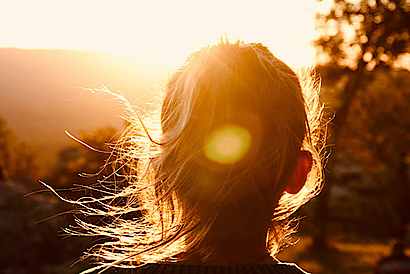 Frau blickt in die Sonne - Qcells Sonnenstrom